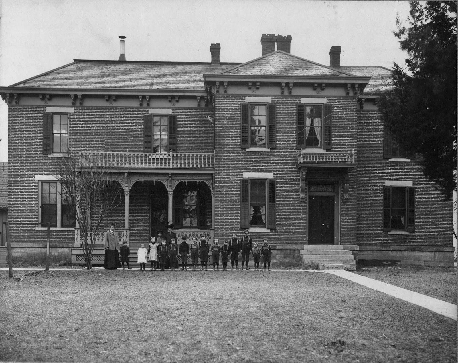 Historic photograph of the Long Home with family gathered on the porch