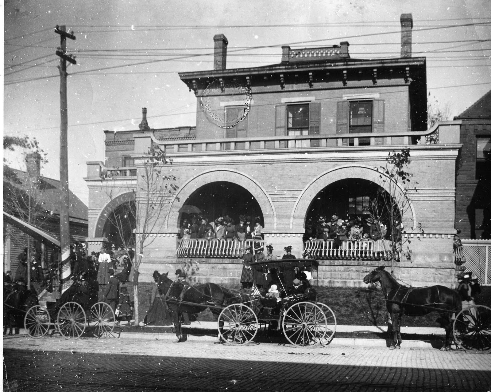 Horse-drawn carriages in front of a Logansport building, early 1900s