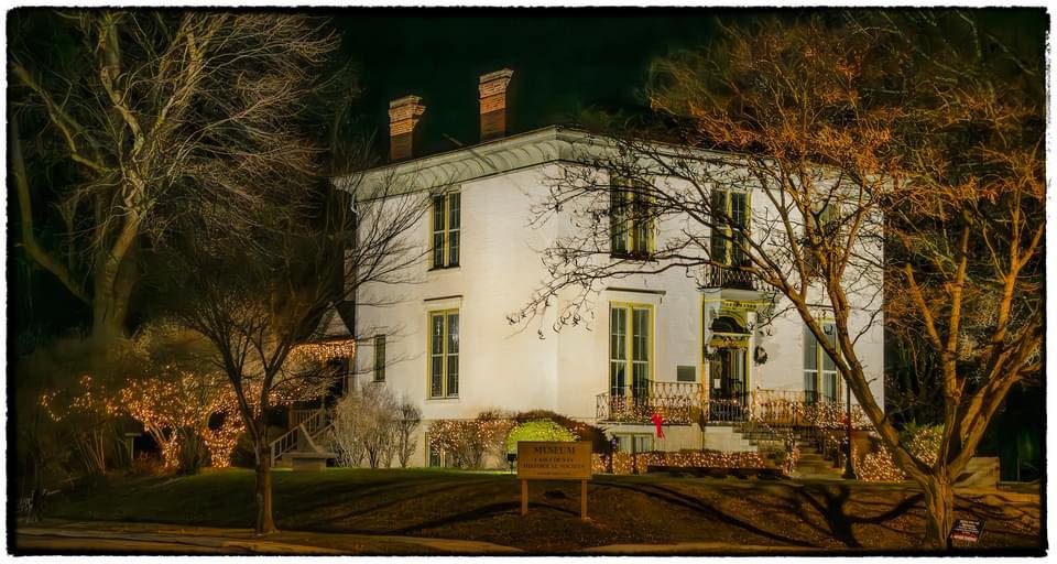 The Long Home Museum lit with holiday lights at night