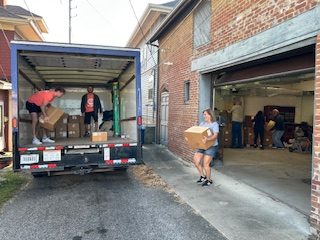 Volunteers unload artifacts from a moving truck at the Cass County Museum